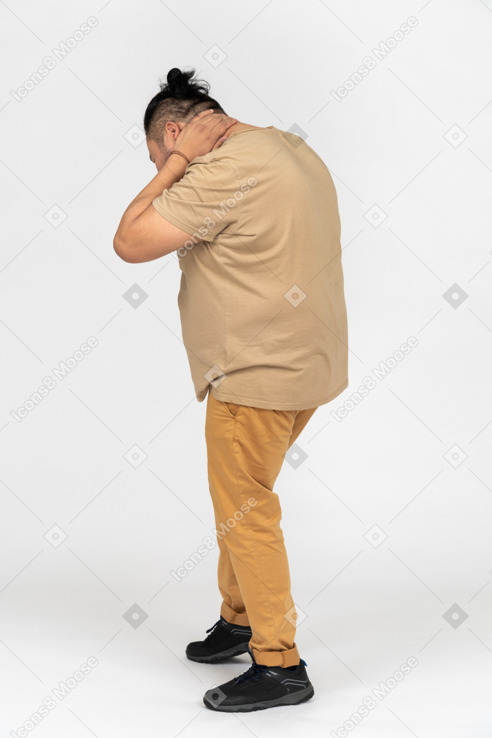 Frustrated asian man holding his neck with both hands