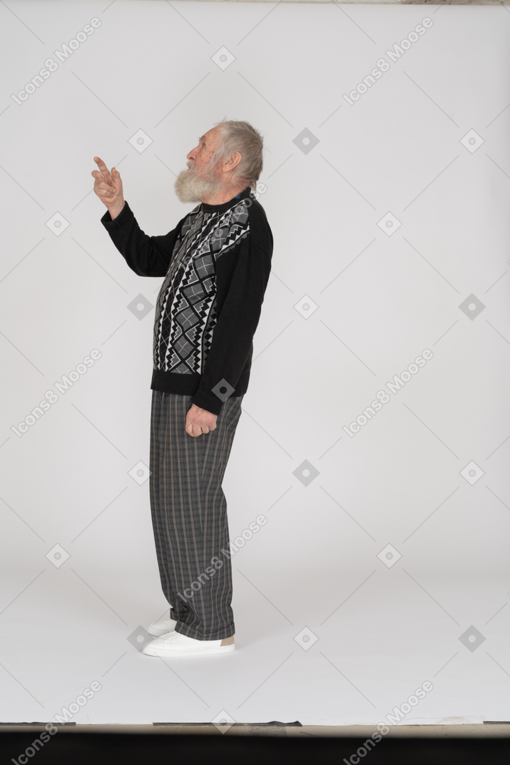 Side view of old man pointing up