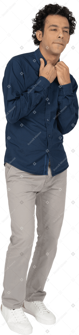 Vista frontal de um homem em roupas casuais tocando o colarinho de sua camisa