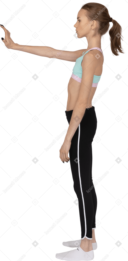 Side view of a teen girl in sportswear outstretching hand