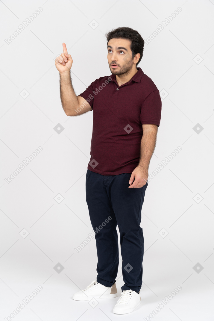 Hombre con ropa informal apuntando hacia arriba
