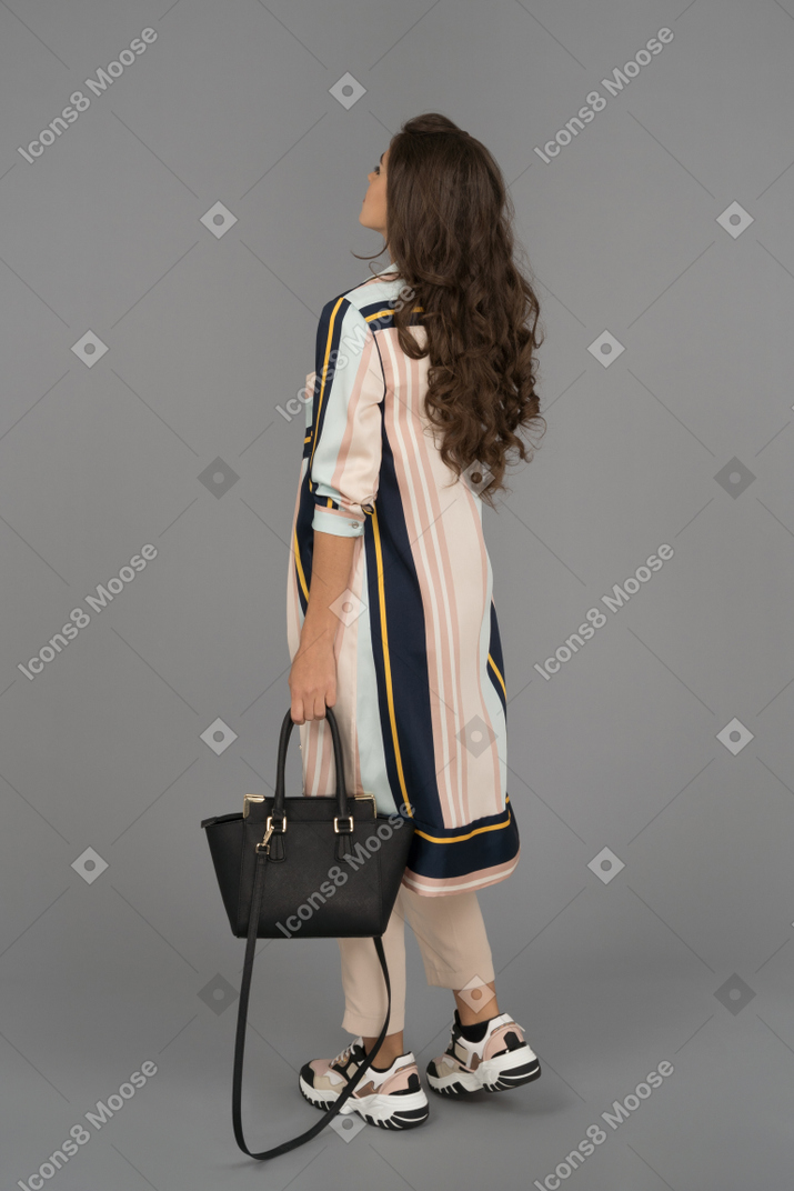 Beautiful young woman posing with handbag
