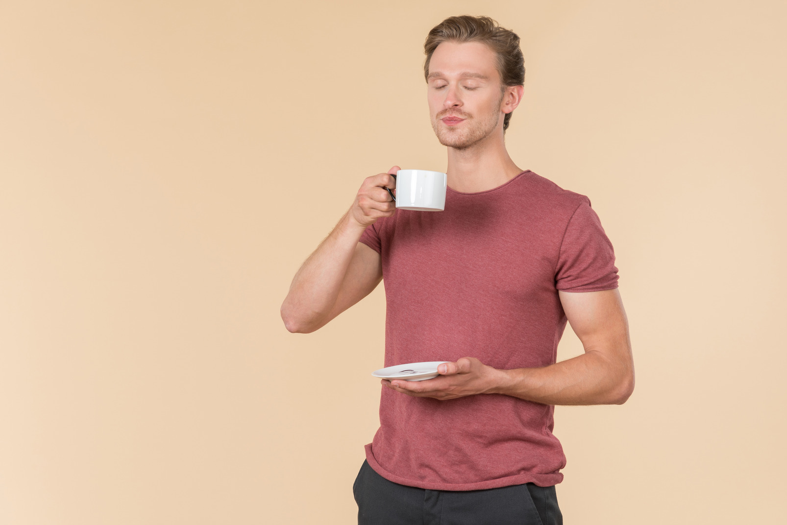 Young guy holding coffee cup and drinking it