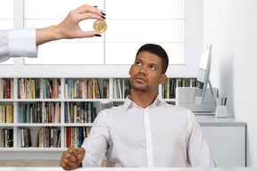 Man looking at hand holding a coin