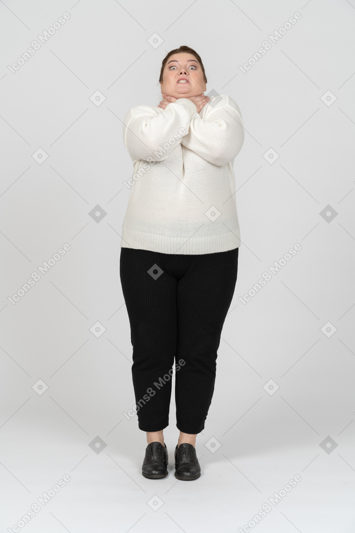Front view of a plump woman in casual clothes chocking herself