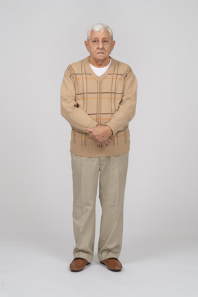 Front view of an old man in casual clothes looking at camera