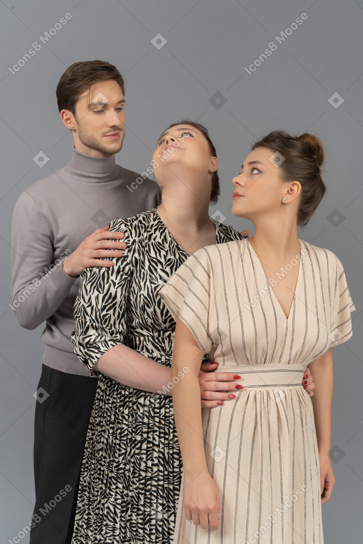 Two young women and a man standing in a row