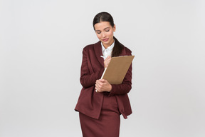 Attractive formally dressed woman taking notes on a clipboard