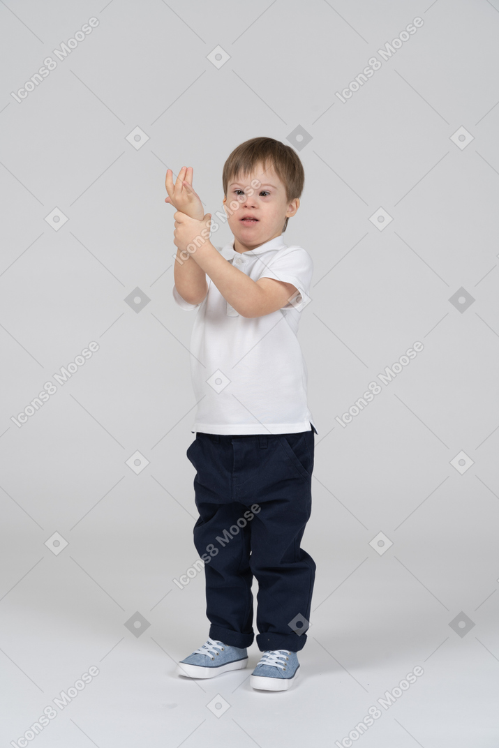 Kleiner junge hält seine hand hoch