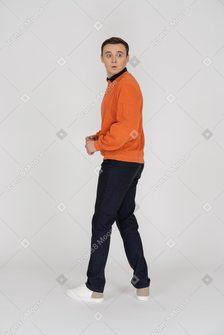 Young man in orange sweatshirt standing