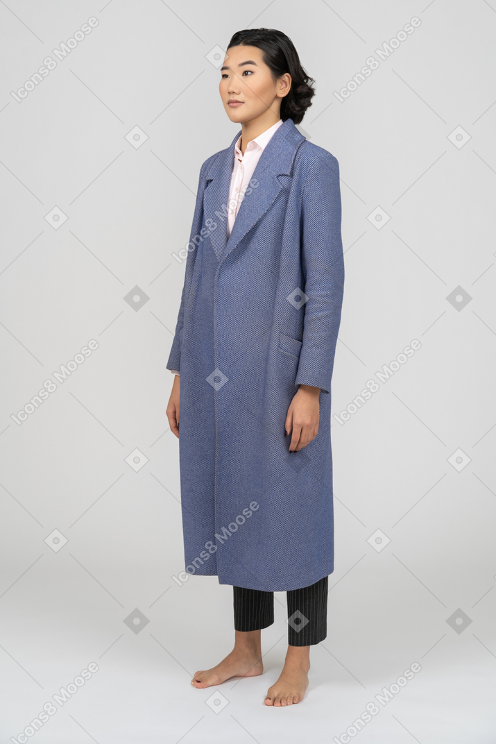 Mujer escéptica con abrigo azul y ceja levantada
