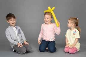 Kids having fun playing with yellow balloon