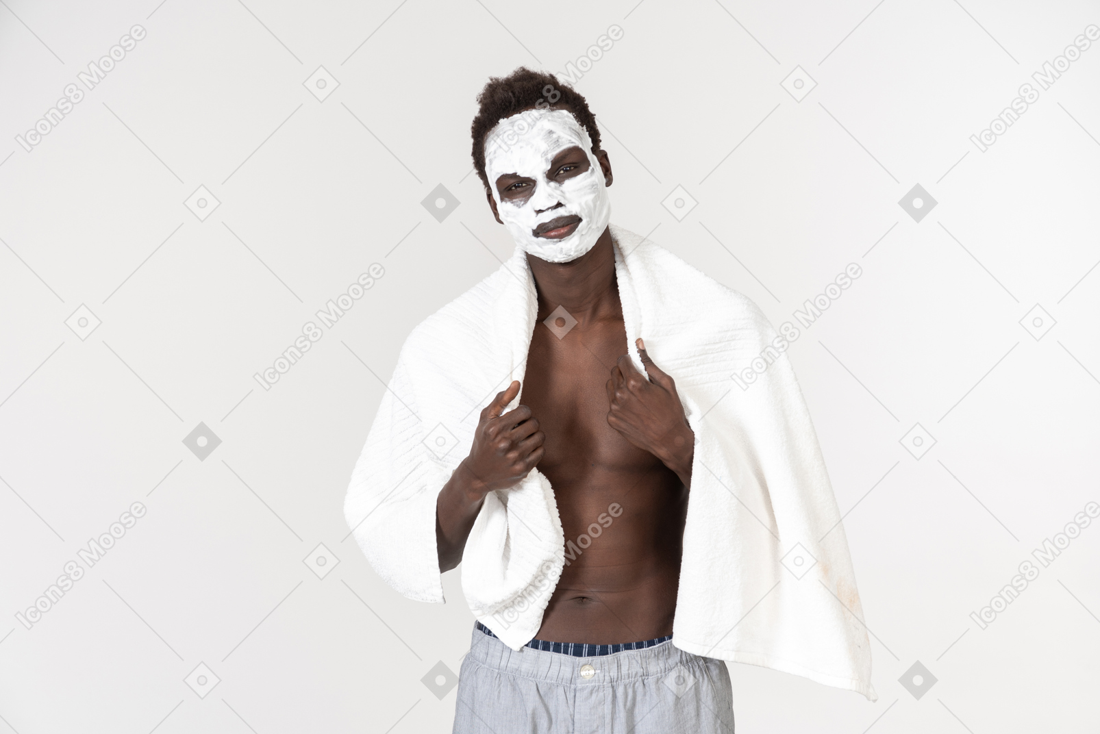 一个年轻的黑人男子腰部有一条白色浴巾，另一个肩膀上有一个关于他的护肤程序