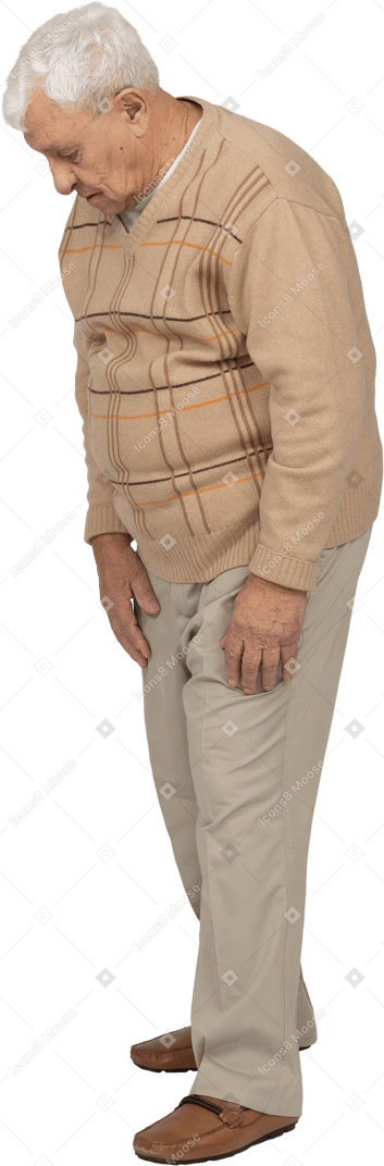 Side view of an old man in casual clothes looking down