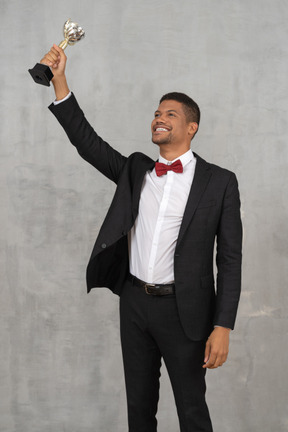 Man holding up award in celebration of his win