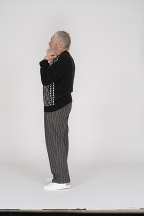Side view of an elderly man adjusting his collar