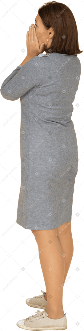 Vue latérale d'une femme impressionnée en robe grise