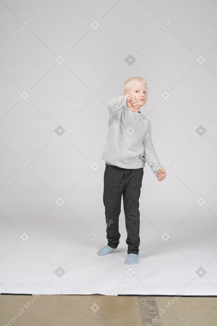 Маленький мальчик показывает сжатые кулаки