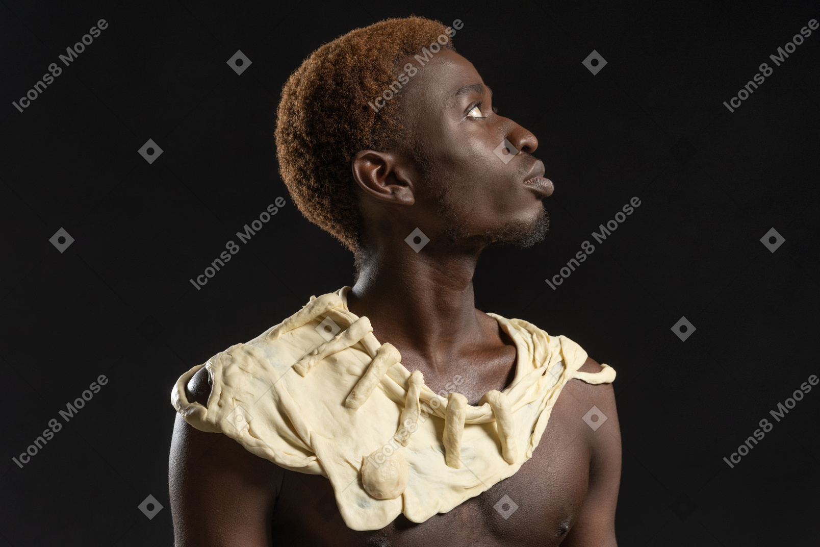 Retrato lateral de um homem africano no fundo escuro com uma coleira de massa
