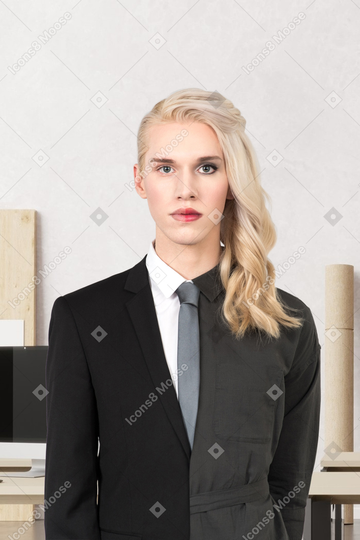 An androgynous person standing in front of a desk