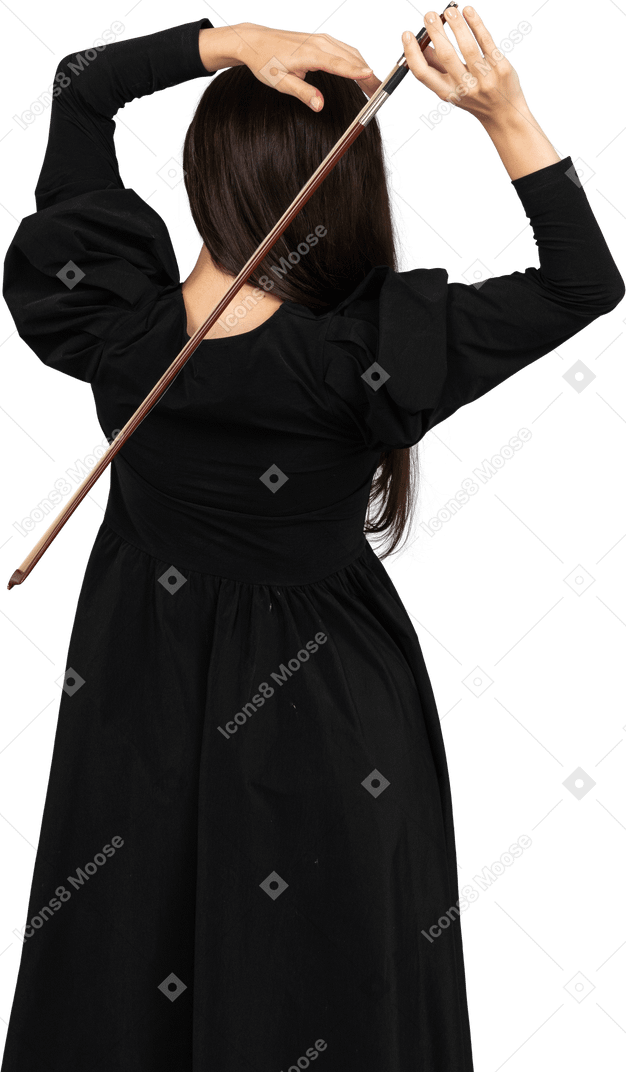 Vista posteriore di una giovane donna in abito nero che tiene il fiocco dietro