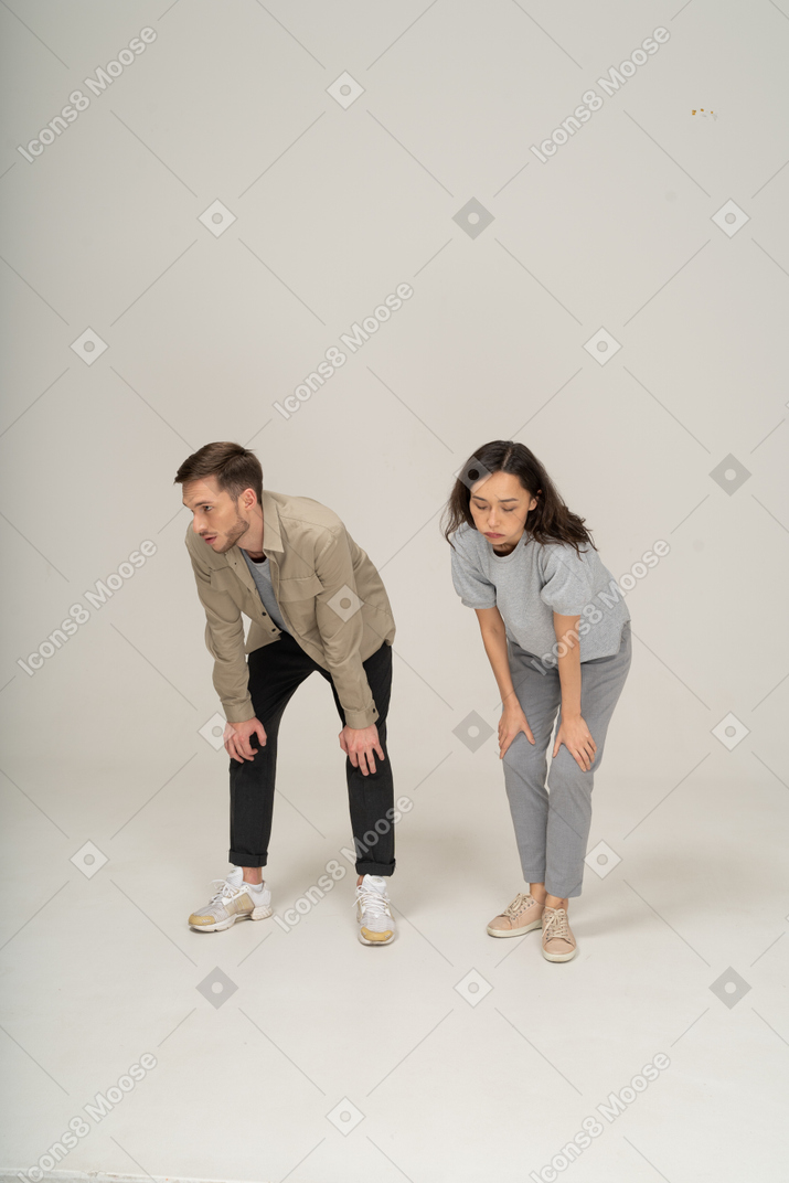 Tired young man and woman leaning on knees