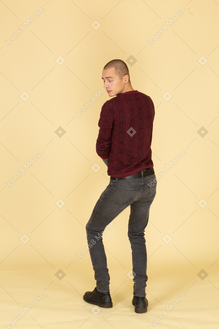 Vista traseira de um jovem de blusa vermelha olhando para o lado