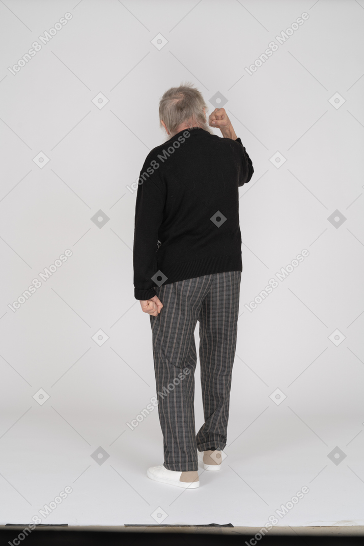 Rear view of old man threatening with fist