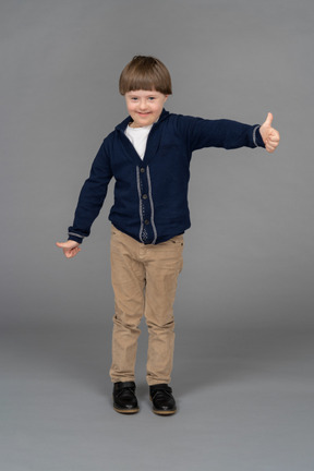 Retrato de um menino mostrando os polegares