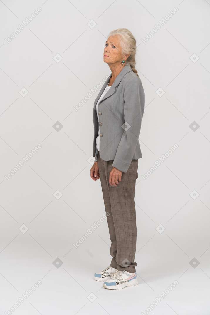 Old lady in grey jacket standing in profile