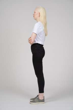 Side view of a young blonde lady holding herself