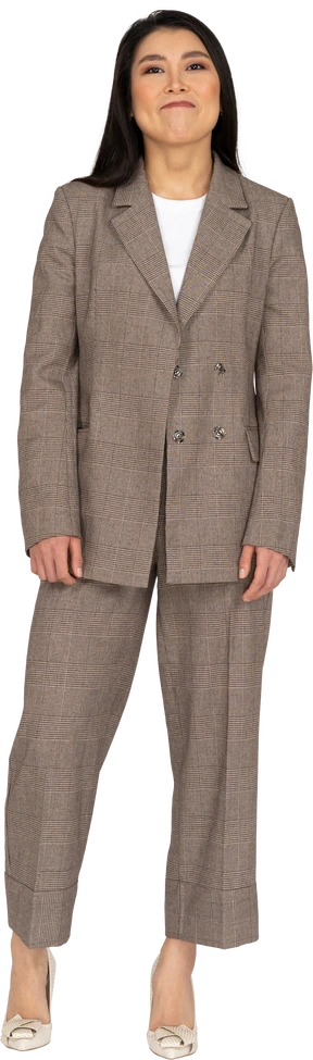 Front view of a smirking young lady in brown business suit