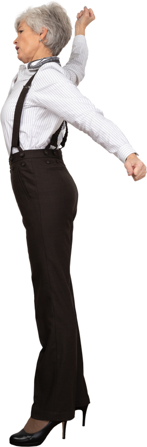 Vista lateral de una anciana en ropa de oficina estirando sus manos