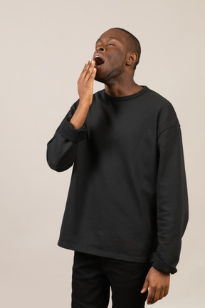 Man in black clothes yawning