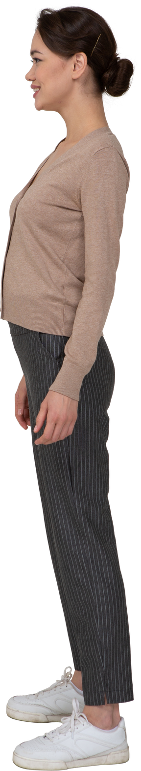 Vue latérale d'une femme souriante en pull et pantalon