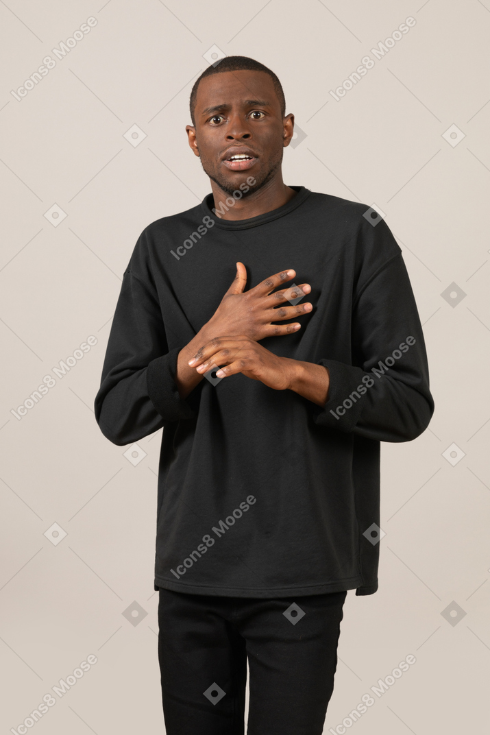 Worried man standing with hand on chest