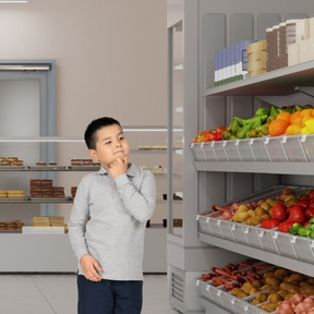 Niño eligiendo frutas y verduras en el supermercado