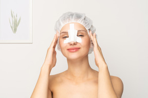 Female patient with bandaged nose touching her head