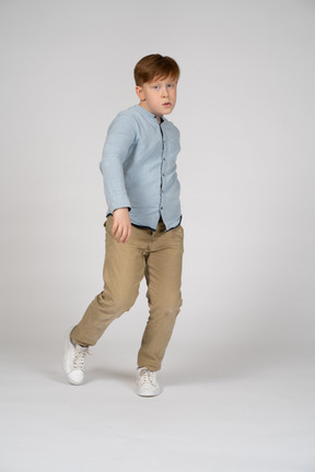A young boy walking on tiptoes
