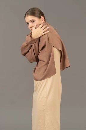 Young woman hugging herself and looking at camera