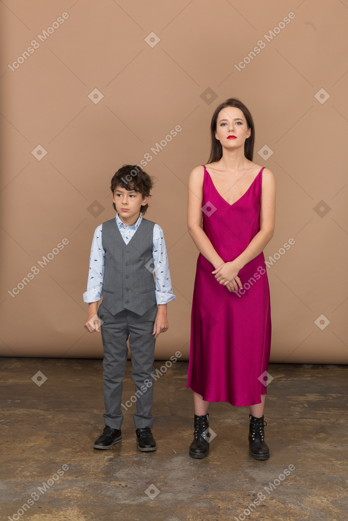 Young woman standing with a boy and smiling