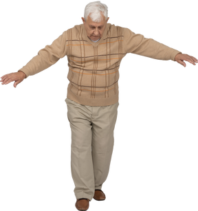 Vue de face d'un vieil homme en vêtements décontractés marchant vers l'avant avec les bras tendus