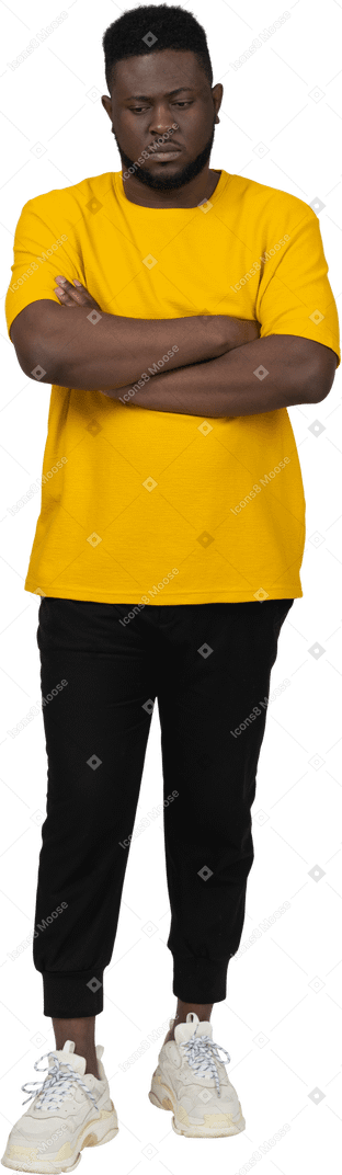 一个身穿黄色 t 恤、双臂交叉的年轻深色皮肤男子的前视图