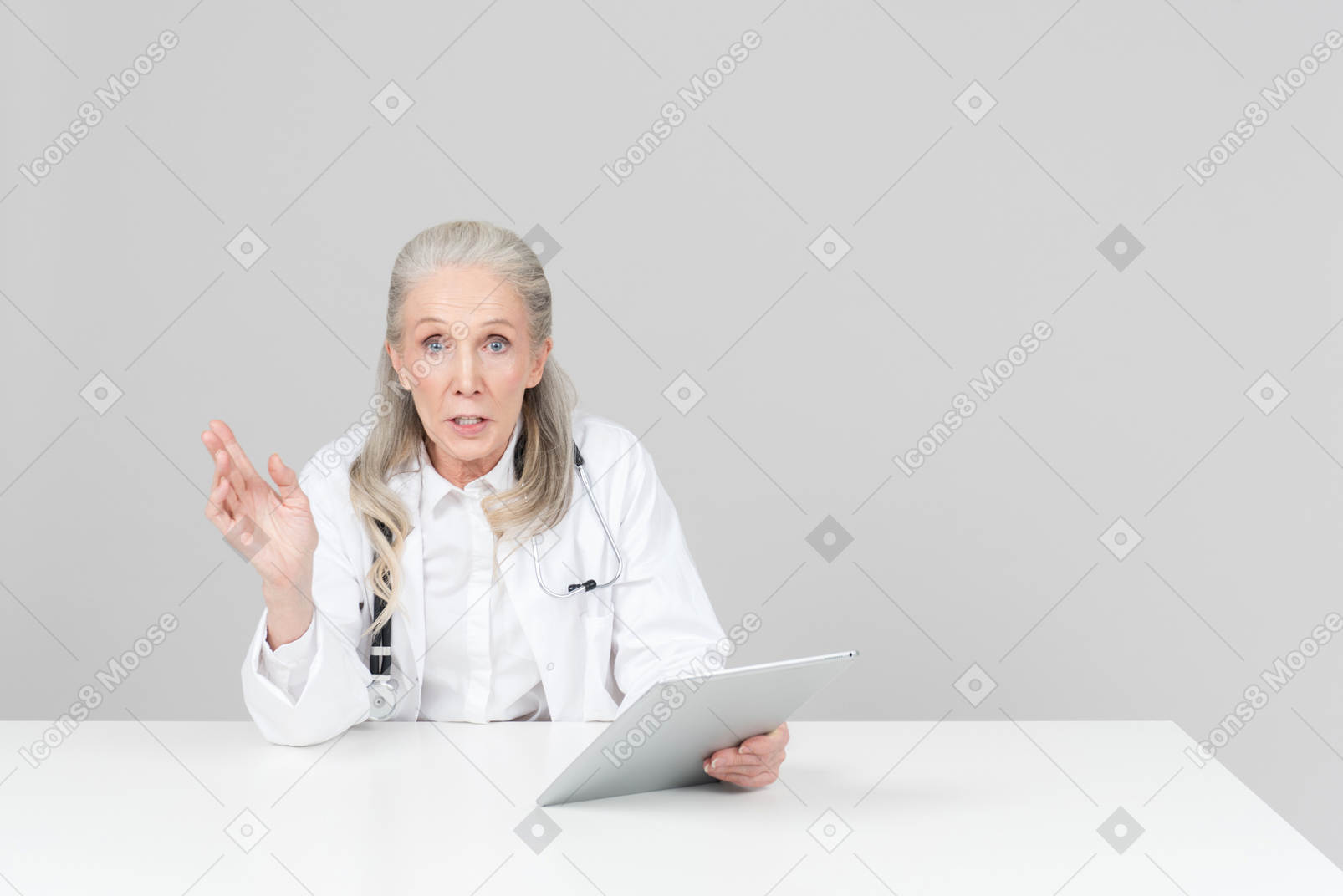 Aged female doctor holding a digital tablet