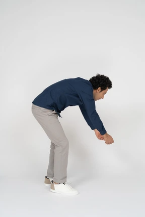 Side view of a man in casual clothes bending down