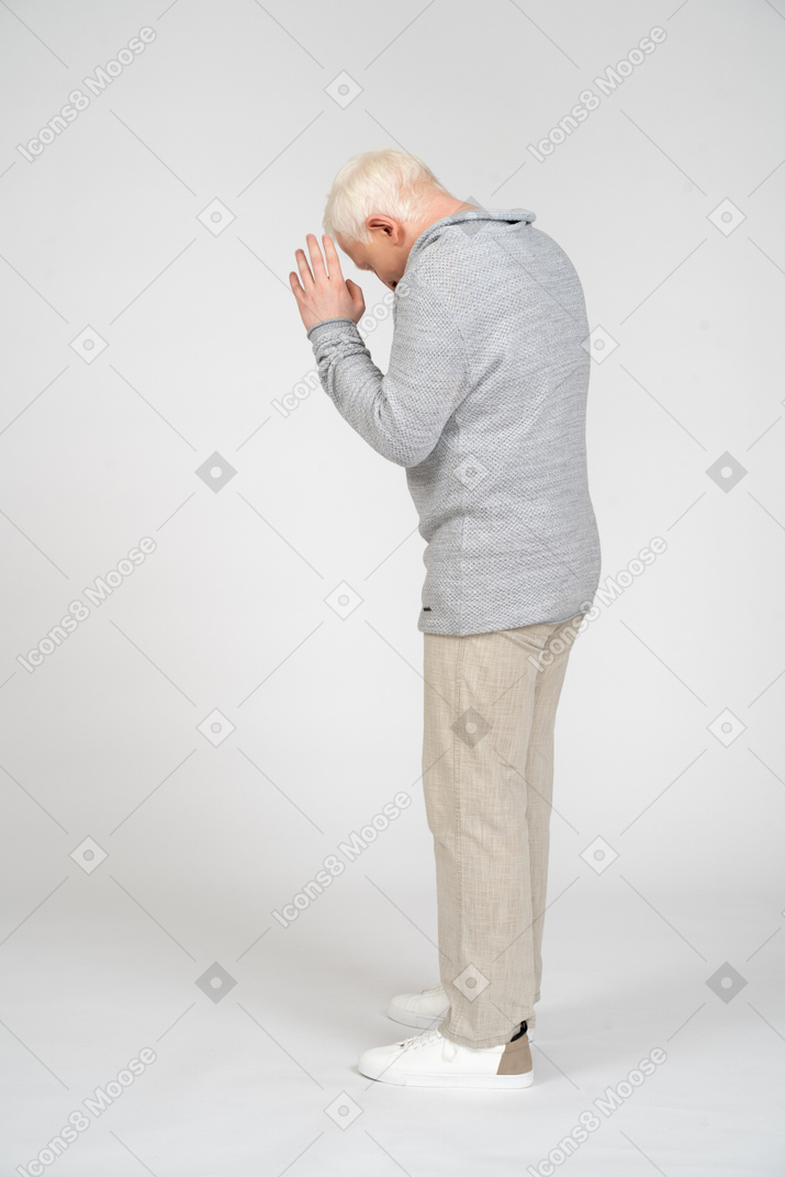Side view of man standing with his hands in prayer position