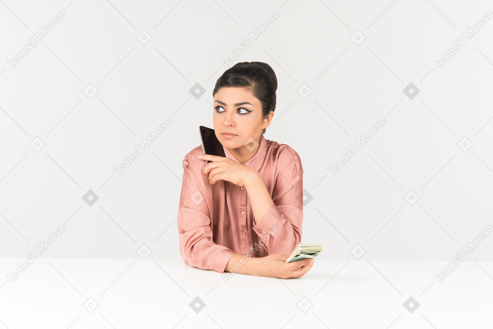 Young indian woman holding money bills and talking on the phone