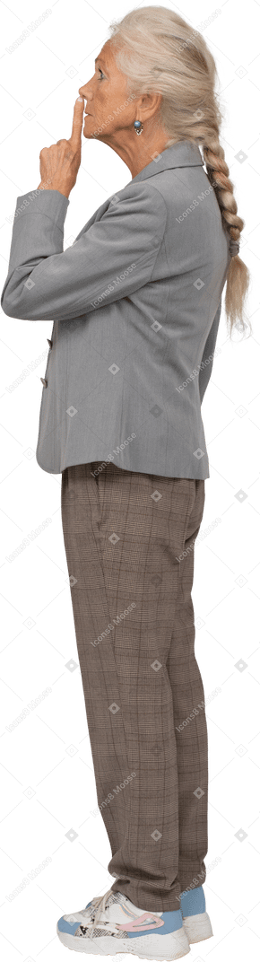 Seitenansicht einer alten dame im anzug, die ein shh-zeichen macht