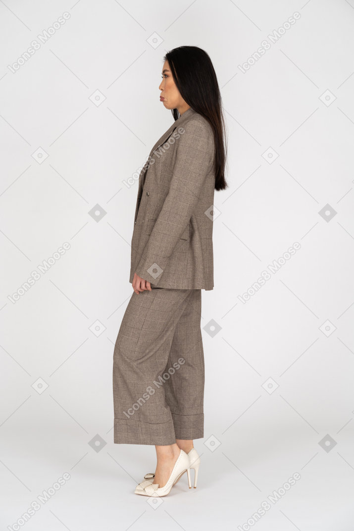 Side view of a displeased pouting young lady in brown business suit