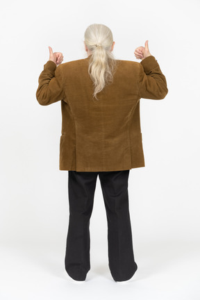 Вид сзади на пожилого мужчину, показывающего большие пальцы вверх